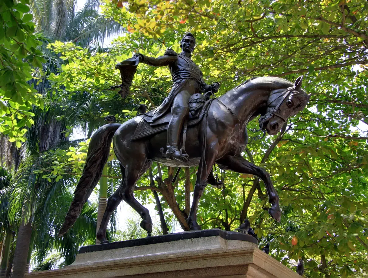 The bronze equestrian statue of Simon Bolivar under trees on his plaza in Cartagena, Colombia