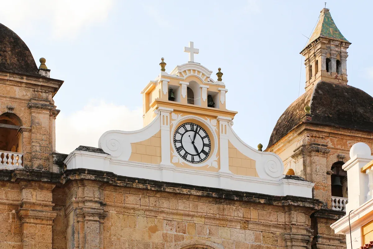 The stone facade and bell gable of the San Pedro Claver church on a Cartagena, Colombia city guide