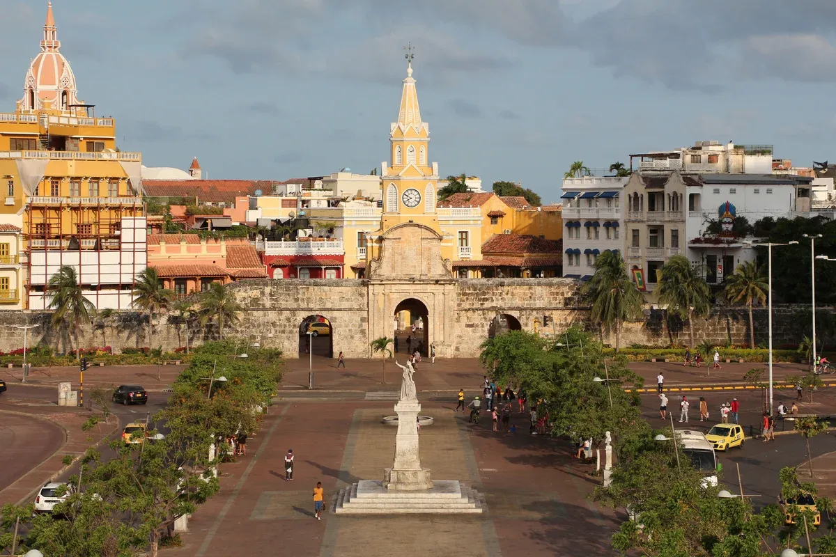 The yellow clock tower gate in the city walls, seen from Plaza de la Paz on a Cartagena, Colombia city guide